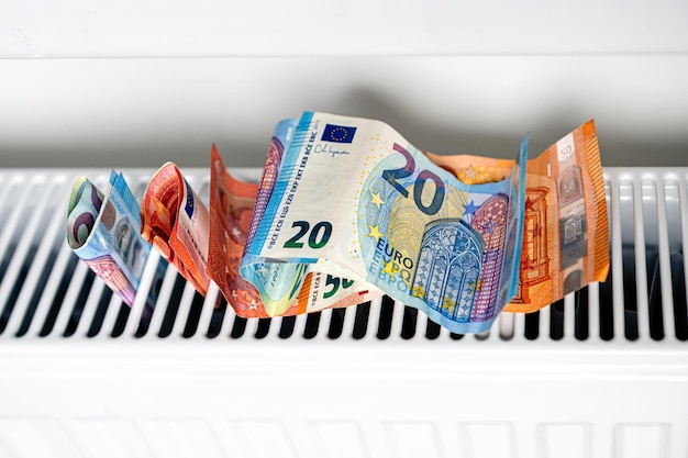 Banknoty euro w grzejniku centralnego ogrzewania zbliżenie na koncepcję drogiego ogrzewania