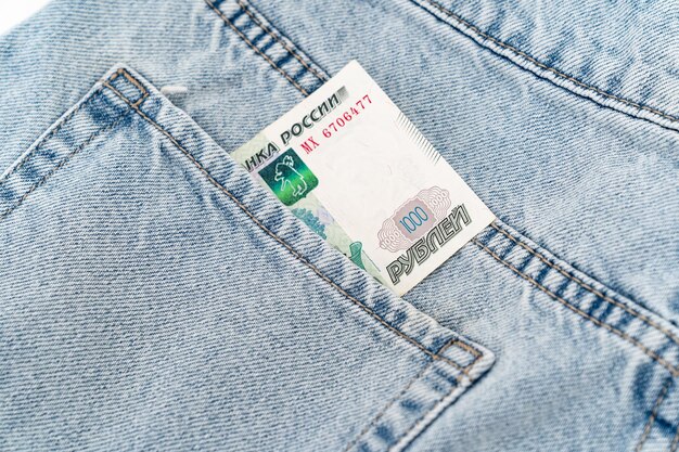 Banknoty w kieszeni niebieskich dżinsów obrót gotówką rosyjski banknot 1000