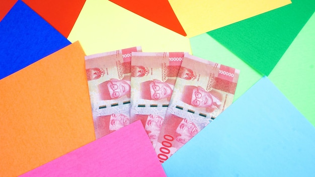 Banknoty walutowe rupii indonezyjskiej o nominale stu tysięcy na białym tle na kolorowym tle
