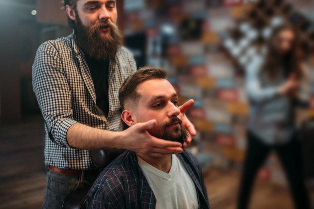 Barber pokazuje swoją pracę klientowi.