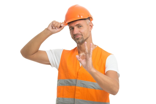 Zdjęcie bardzo dobrze. podekscytowany elektryk pokaż ok gest. przystojny pracownik usług na białym tle. robotnik asfaltowy na budowie. po prostu perfekcyjnie. pozytywny człowiek w kasku. hydraulik jest pracownikiem wodociągowym.