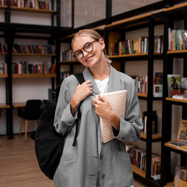 Zdjęcie bardzo młoda kobieta pozuje w bibliotece