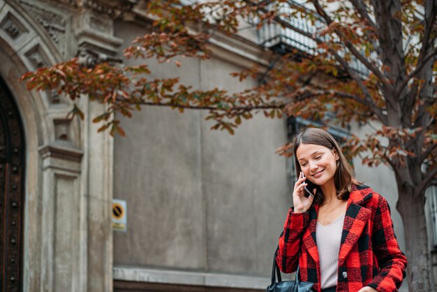 Bardzo Młoda Kobieta Spaceru Na Ulicy Za Pomocą Telefonu