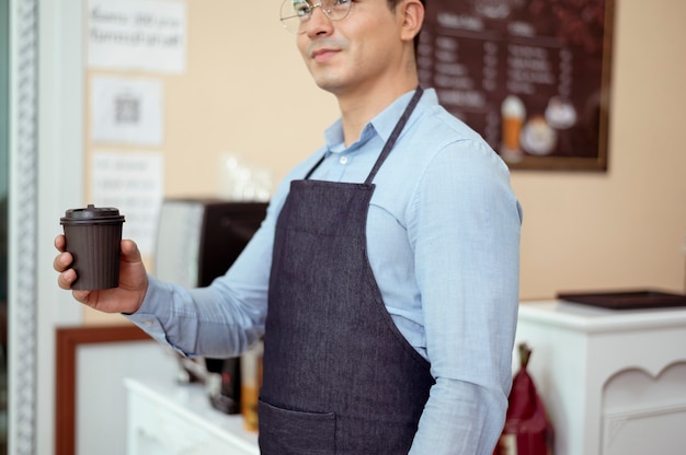 Barista Bierze Kubek Gorącej Kawy I Piekarni Do Oferowania Klientowi W Kawiarni