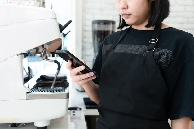 Barista Otrzymuje Zamówienia Na Kawę Ze Smartfonów W Kawiarni. Koncepcje Dla Małych Firm