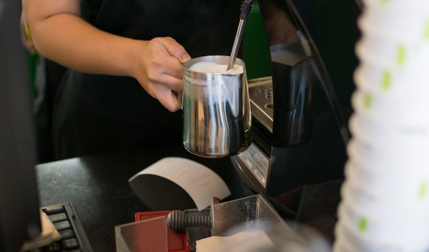 Barista parujące mleko do kawy