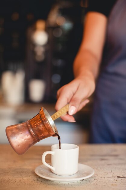 Barista parzy kawę w czajniku