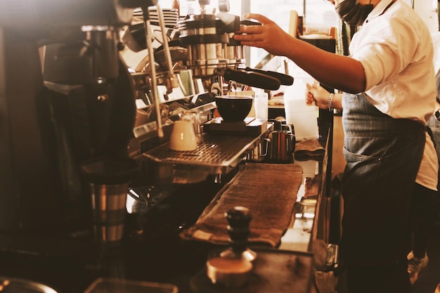 Barista robi kawę w kawiarni.