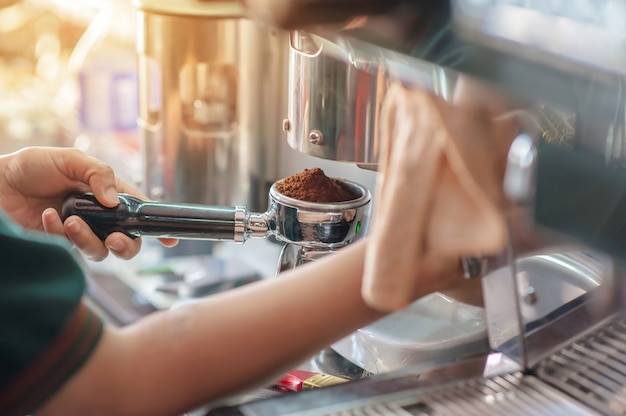 Barista trzyma sabotaż z prasowania mielonej kawy