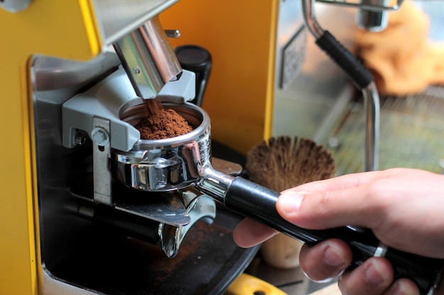 Barista trzymający maszynę do kawy espresso w sklepie z kofeiną