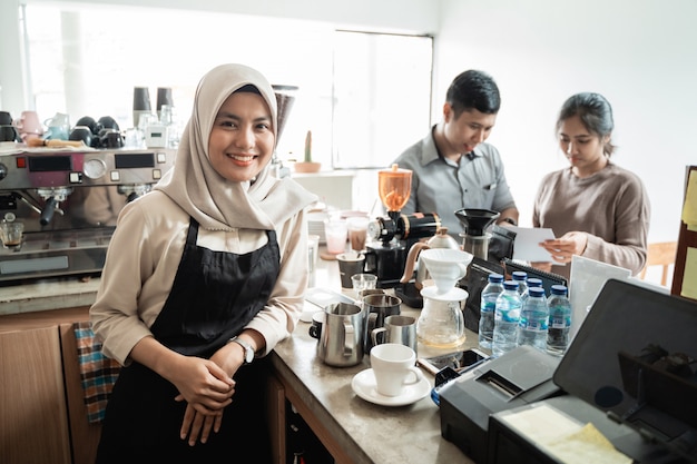 Barista uśmiecha się, gdy robi kawę dla klienta