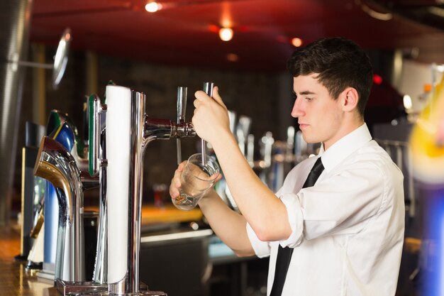 Barkeeper trzyma szkło przed piwną aptekarką przy barem