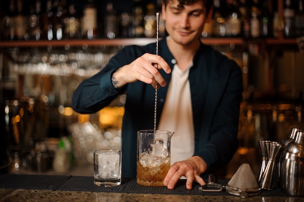 Barman Brunet Mieszający Napój Alkoholowy W Szklance Z Lodem