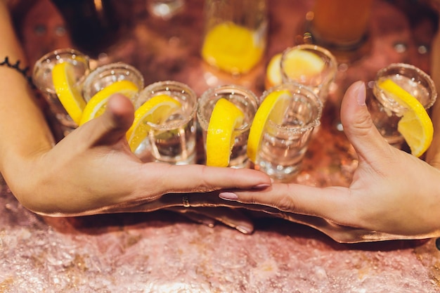Barman nalewa mocny napój alkoholowy do małych szklanek na shotach barowych