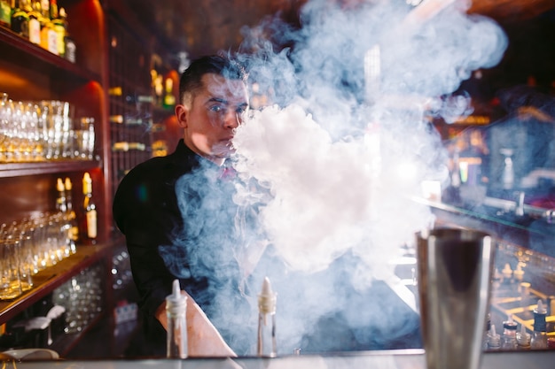Barman nalewa świeży koktajl w fantazyjnym szkle