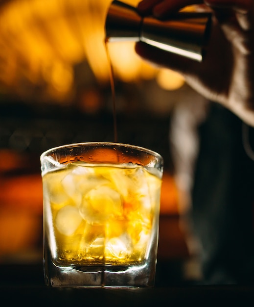 Zdjęcie barman nalewa whisky na bar