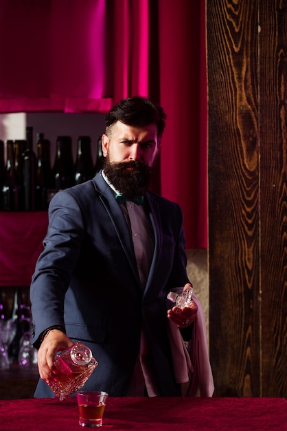 Barman nalewający brandy w szklance whisky Bar man z brandy lub koniakiem