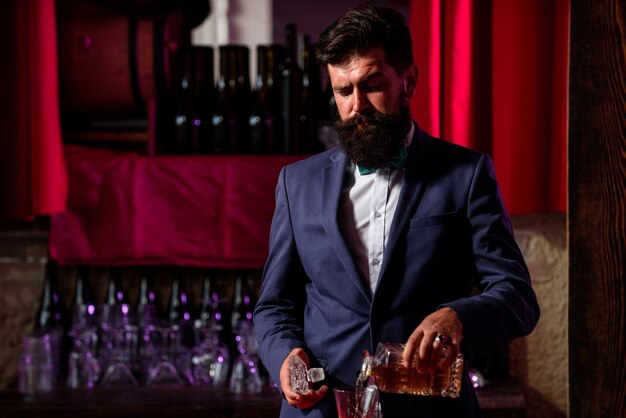 Barman nalewający brandy w szklance whisky Napój alkoholowy