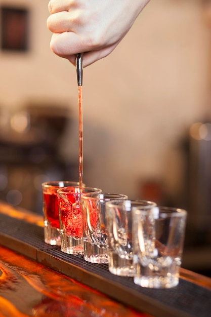 Barman napełnia kilka szklanek z rzędu jednocześnie