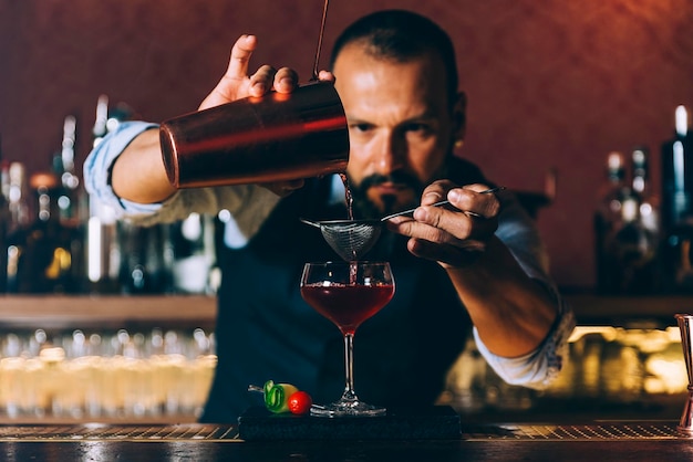 Barman przygotowujący koktajl w barze