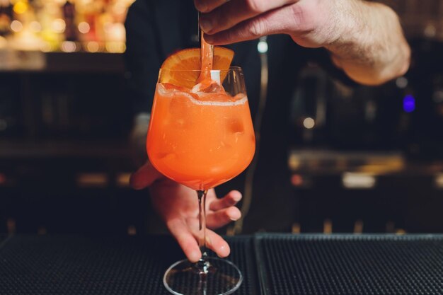 Barman przygotowuje alkoholowy aperitif aperolowy koktajl spritz