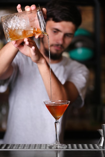 Barman przygotowuje koktajl na ladzie barowej