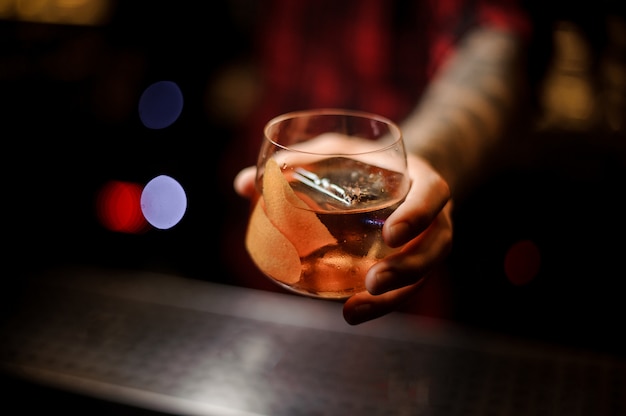 Barman ręki trzymającej szklankę whisky dof świeżego koktajlu Kapitana Jamesa Cooka