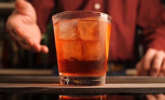 Barman serwuje koktajl Negroni na blacie barowym