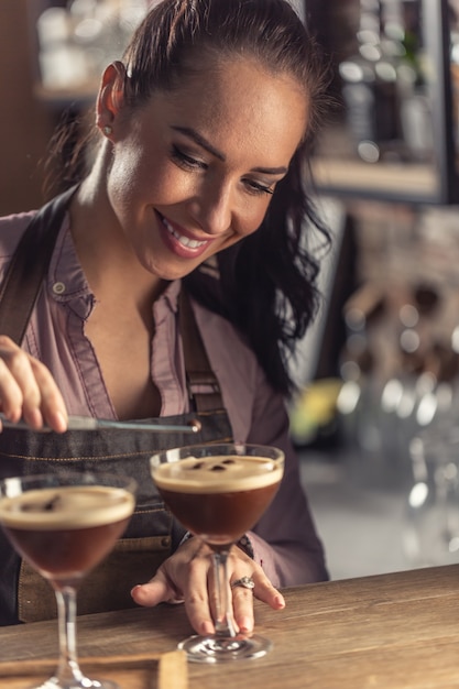 Barman umieszcza ziarna kawy na wierzchu koktajlu espresso martini.