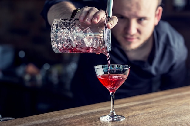 Barman w pubie lub restauracji przygotowuje drinka.