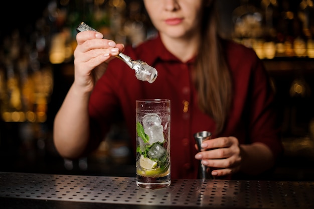 Barmanka W Czerwonej Sukience Przygotowuje Mojito, Dodając Lód