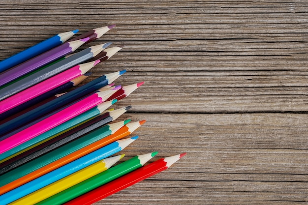 Barwioni ołówki na drewnianym tle