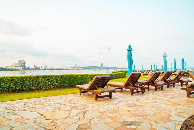 basen z krzesłami lub basen z łóżkiem i parasol wokół basenu z plażą morską w Pattaya w Tajlandii