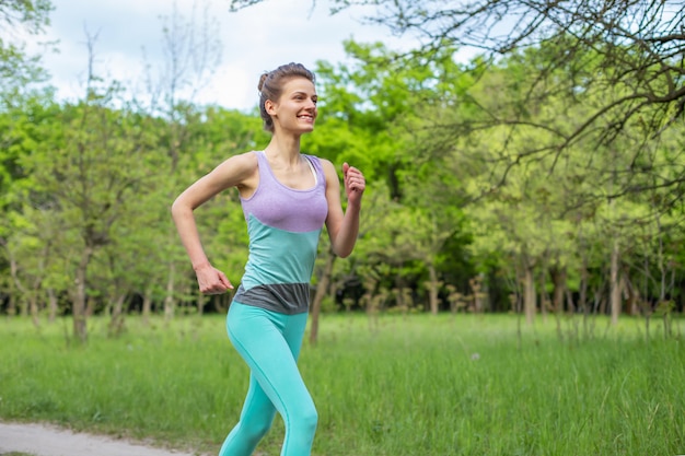 Bawi się brunetki dziewczyny jogging w parku.