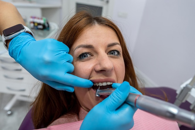Zdjęcie beautiful young woman is having a dental treatment and examination in a dental office