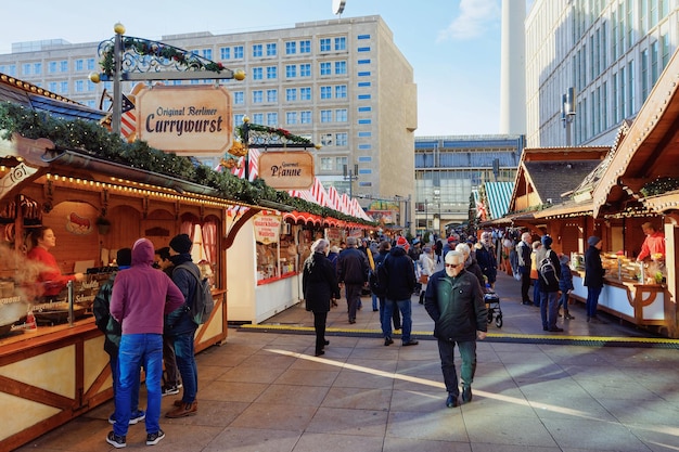 Berlin, Niemcy - 10 grudnia 2017: Ludzie na Jarmark Bożonarodzeniowy na Alexanderplatz w zimie Berlin, Niemcy. Dekoracje na jarmark adwentowy i stragany z artykułami rzemieślniczymi na bazarze.