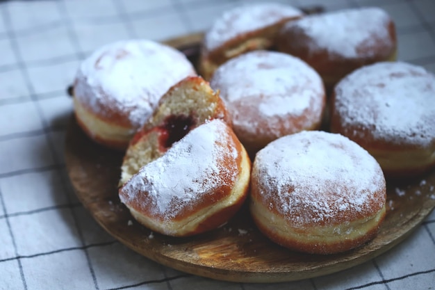 Berliner pączki w cukrze pudrze na drewnianej tacy