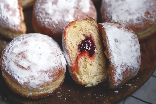 Berliner pączki w cukrze pudrze na drewnianej tacy