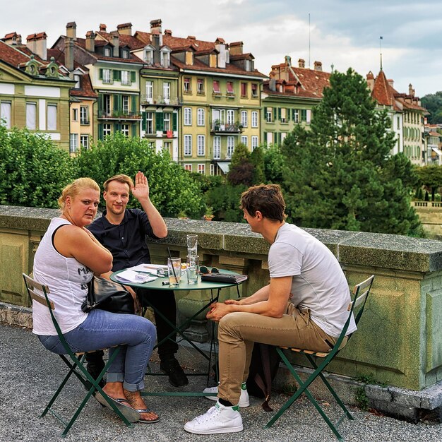 Zdjęcie bern, szwajcaria - 31 sierpnia 2016: przyjaciele w kawiarni na świeżym powietrzu na munsterplatform w starym centrum miasta bern, szwajcaria