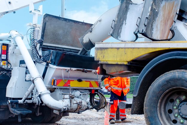 Beton jest rozładowywany z betoniarki do pompy do betonu Ładowanie mokrego betonu do pompy