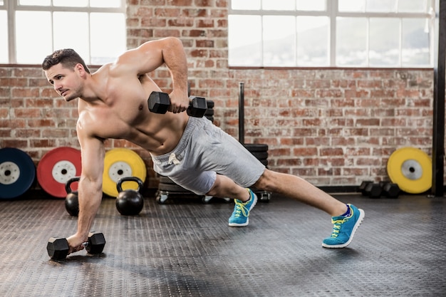 Bez koszuli mężczyzna ćwiczy z dumbbell