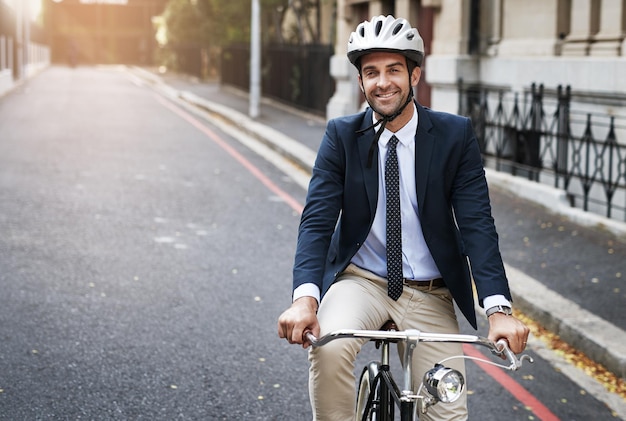 Bezpieczeństwo przede wszystkim Ujęcie przystojnego młodego biznesmena jadącego rano na rowerze do pracy