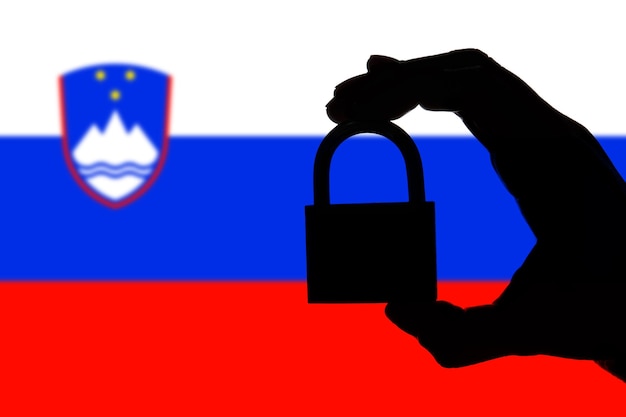 Bezpieczeństwo Słowenii Sylwetka dłoni trzymającej kłódkę nad flagą narodową
