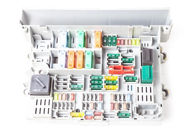 Bezpieczniki samochodowe na białym panelu z przekaźnikiem i wielokolorowymi oznaczonymi obudowami urządzenie zabezpieczające otwiera obwód elektryczny, gdy prąd przepięcia Diagnostyka sieci zasilającej w serwisie samochodowym