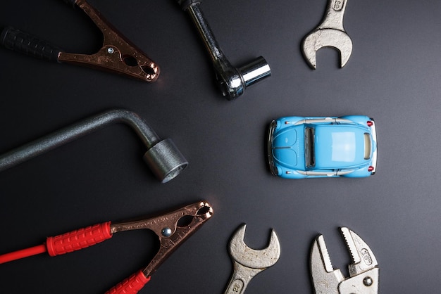 Zdjęcie bezpośredni widok narzędzi ręcznych z samochodem zabawkowym na szarym tle