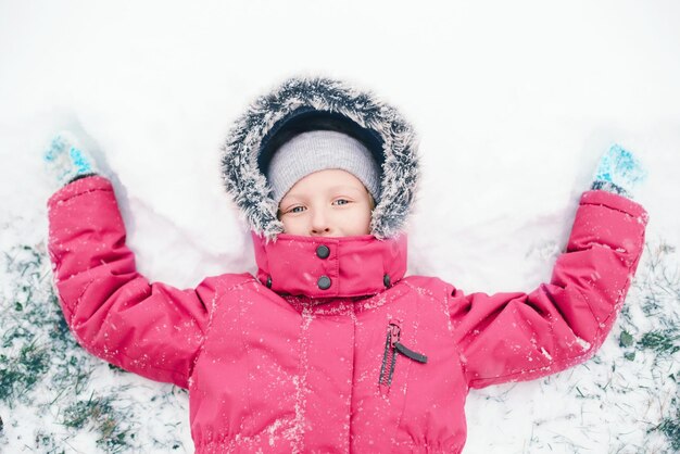 Zdjęcie bezpośrednio nad portretem dziewczyny robiącej anioła śniegu na lądzie