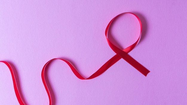 Bezpośrednio nad ujęciem wstążki o świadomości AIDS na różowym tle