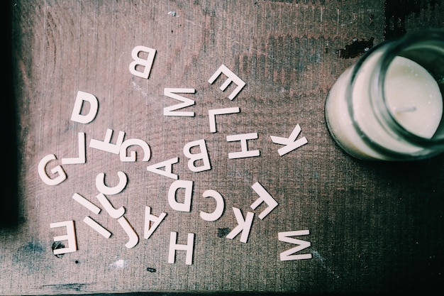 Zdjęcie bezpośrednio nad zdjęciem alfabetu przez szklankę z mlekiem na stole