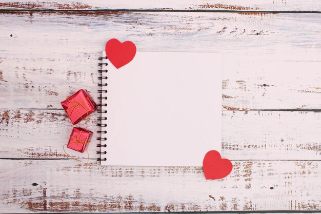 Zdjęcie bezpośrednio nad zdjęciem pudełek z prezentami i czerwonego serca na stole