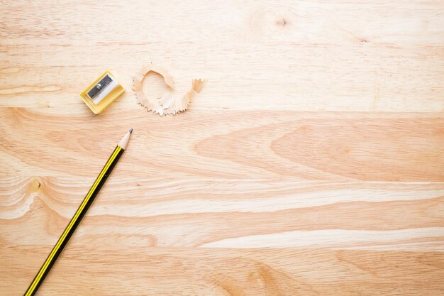 Zdjęcie bezpośrednio powyżej strzału ołówka i ostrego na drewnianym stole